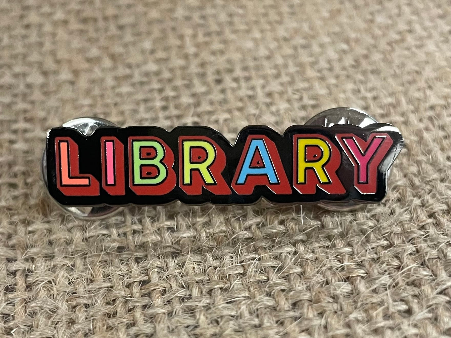 the front of the library pin against a brown burlap background